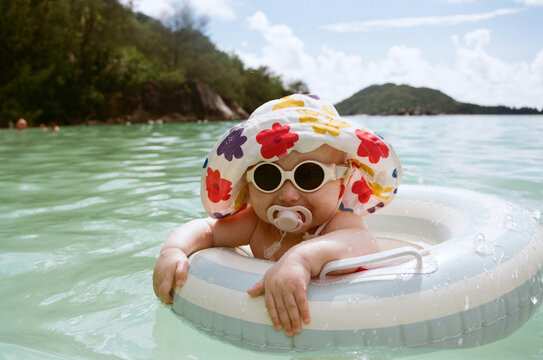 A toddler enjoys time spent in the ocean with an inflatable ring.