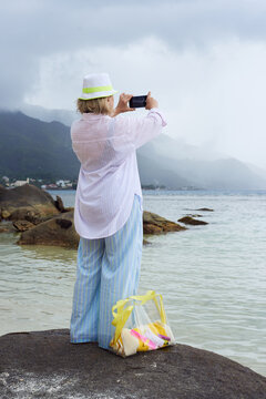 Woman takes smartphone picture at the beach