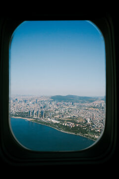 View of a City by the Sea From an Airplane Window During Daytime