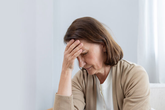 Mature woman has her hand on her forehead suffer from headache