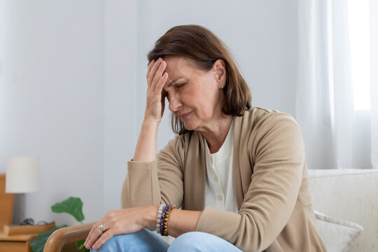 Mature woman has her hand on her forehead suffer from headache
