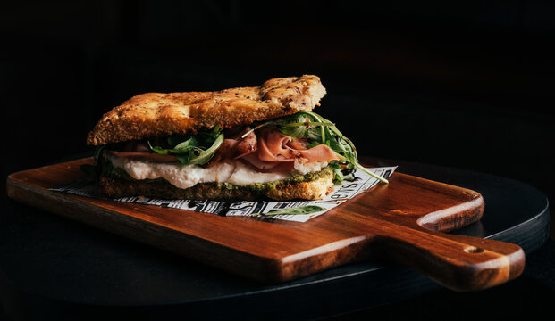 Gourmet toasted focaccia on wooden board with dark backdrop