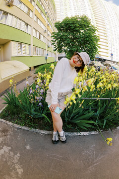 Person Siting in Garden With Yellow Flowers by a Building