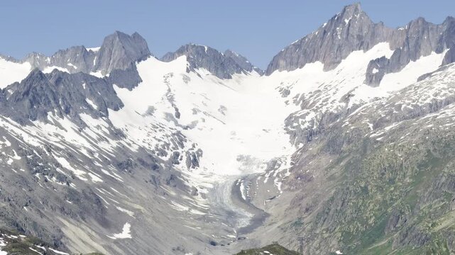 Telephoto view of a glacier tongue descending from a snow-filled