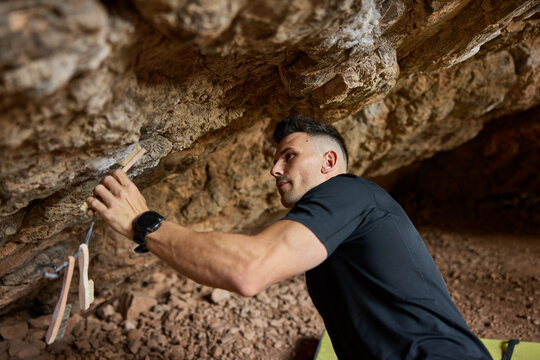 Climber prepares for an ascent in a rocky cave in the afternoon