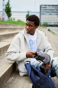 Young Man Prepares to Run by a Busy Urban Area Near the Steps