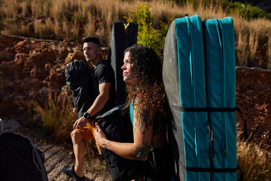 Climbers carry pads on their backs at an outdoor bouldering site