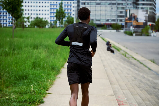 Runner Enjoys Exercise in City Park During Warm Afternoon