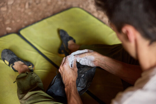 Climber applies chalk to hands before starting the route indoors