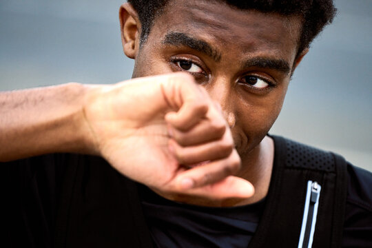 Young Man Wipes Sweat From Forehead After Workout Session