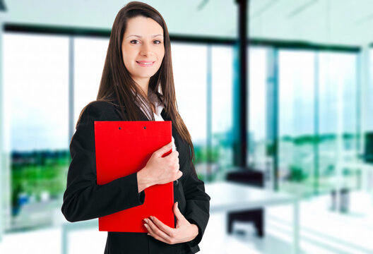 Professional businesswoman with clipboard in office