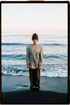 Woman wearing oversized blazer standing on  beach