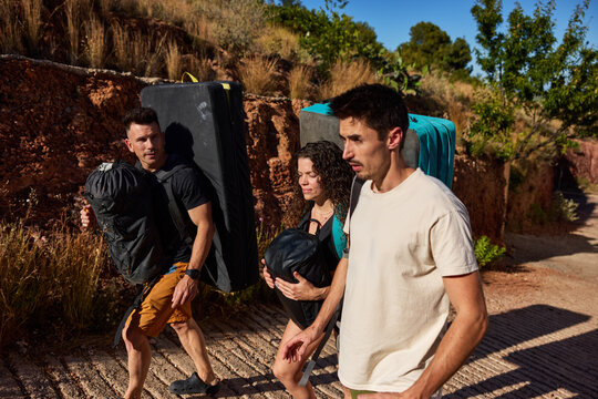 Hikers carrying equipment on a trail in the afternoon