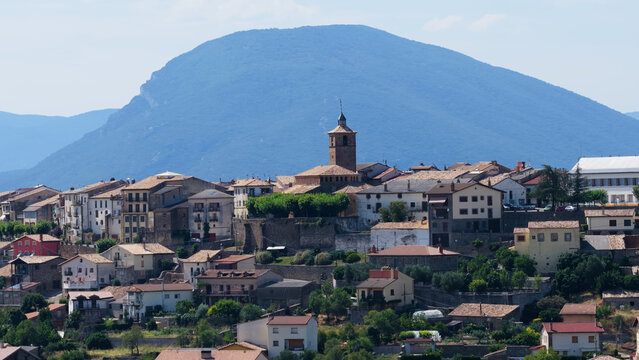 Berdun village and its historic church among traditional buildings, nestled against the Pyrenees mountains in Aragon, Spain