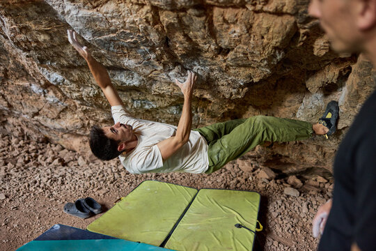 Climber practices techniques on rock wall inside cave