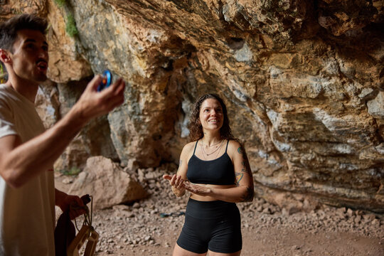 People inside a cave preparing for rock climbing at a sunny time