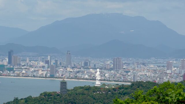 Capturing a beautiful panoramic daytime view of Danang, Vietnam. The city skyline stretches along the coast, with Linh Ung Pagoda and Lady Buddha statue prominent