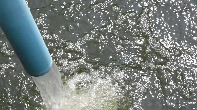 fresh water flow gushing from pvc pipe into pond, aquaculture water treatment system