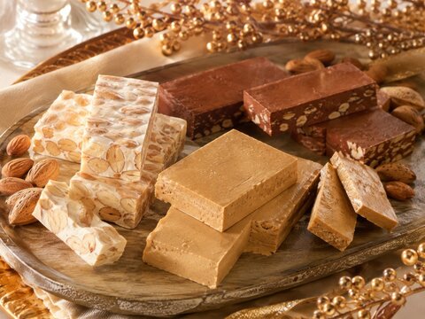 Traditioneller spanischer Turr&oacute;n in verschiedenen Sorten mit Mandeln als beliebte S&uuml;&szlig;igkeit zu Silvester. Festlich angerichtet und ideal f&uuml;r authentische Neujahrsmotive mit tradition.