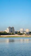 Obraz premium Modern city skyline with waterfront buildings and a clear blue sky
