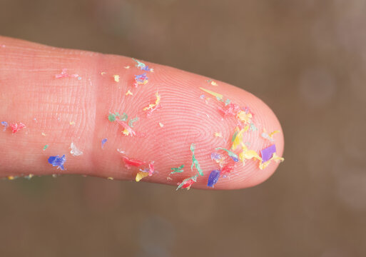 Tiny pieces of microplastic on a human finger