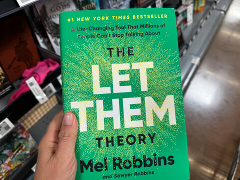 Mesa, Arizona - June 28, 2026: Hand holds a The Let Them Theory book by Mel Robbins