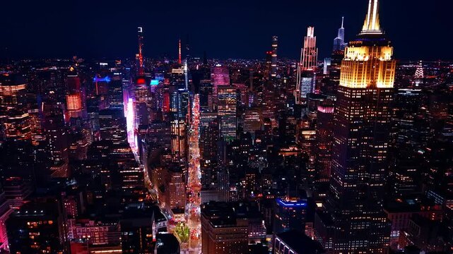 Descend over the luminous street of Manhattan with lots of cars on. Night scenery of New York City, USA from drone.