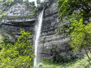 Majestic waterfall cascading from tall rocky canyon wall. © Sheikh