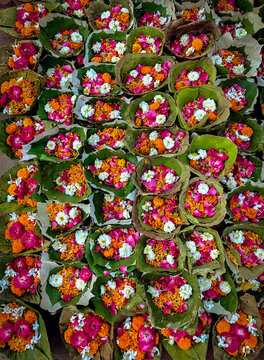 Traditional flower offerings in leaf bowls for devotees at Haridwar's sacred Ganga River, India.