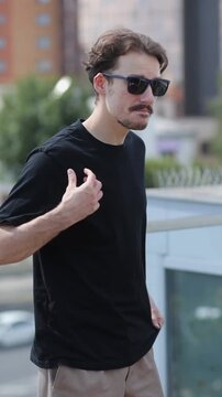 Man wearing black blank t-shirt with space for your logo or design. Mock up. Vertical 	