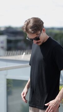 Man wearing black blank t-shirt with space for your logo or design. Mock up. Vertical 	