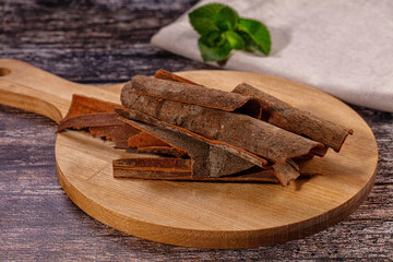 Cinnamon sticks on wooden cutting board with mint leaf © Andrei Starostin