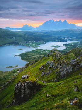 Lofoten islands aerial view and man hiker standing alone on cliff in mountains travel in Norway, adventure summer vacations tour outdoors beautiful destination midnight sun scenery in Vestvagoya