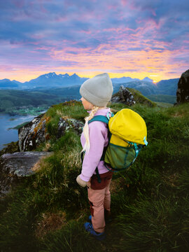 Child girl with backpack explore hiking trails in Lofoten islands vacations trip outdoors kid travel in Norway, family summer holidays tour, 5 years old kid enjoying midnight sun view nature discovery