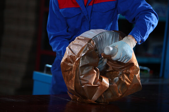 Worker packs finished bearing. Oiled parchment for packaging metal products. Finished products at factory. Workshop at heavy industry plant. Heavy industry
