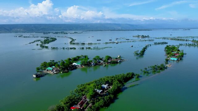 SUNAMGANJ, BANGLADESH - JULY 03, 2026: An aerial drone Video shows isolated wetland villages surrounded by vast water during the monsoon season at Tanguar Haor in Sunamganj, Bangladesh.