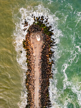 Top-Down Drone View of the Jetty with Fishermen, Lighthouse and People Walking Between the Sea and River in Torres, Brazil