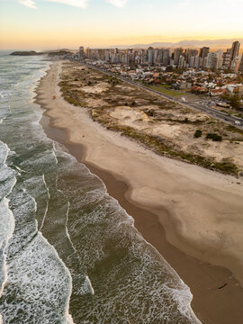 Drone View of Torres Beach with Dunes, Vegetation and City Buildings at Sunset, Brazil