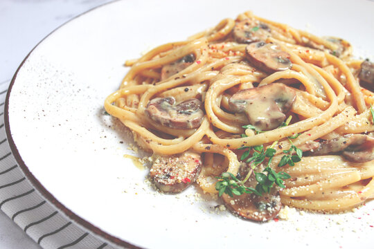 on a white plate, spaghetti with mushrooms, in cream sauce, homemade, no people,