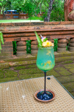 A Glass with blue cocktail or Mojito on table, lemonade or cocktail with mint or Caipirinha,fruits beverage,refreshing summer drink recipe,menu for restaurant,selective focus.