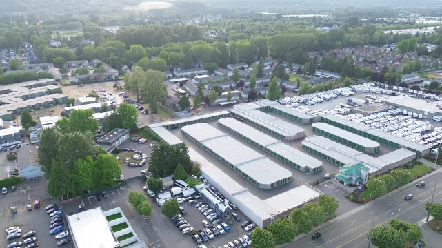 Logistics landscape vista Interstate 167 borders vast clusters of storage units defining Kent business zone. Rows of vehicle shelters align in repeating patterns beneath summer canopy cover in WA