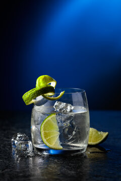Vodka with lime and ice cubes in a fogged up glass.