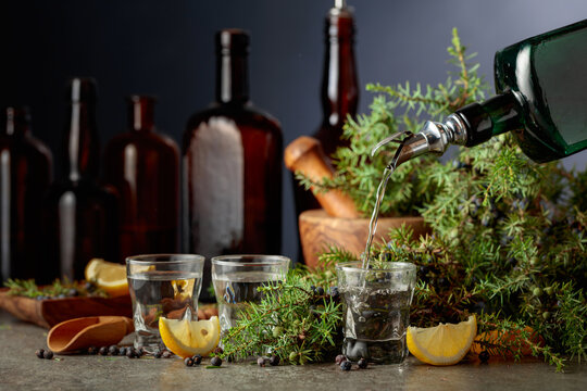 Gin is poured from a vintage bottle into a glass.
