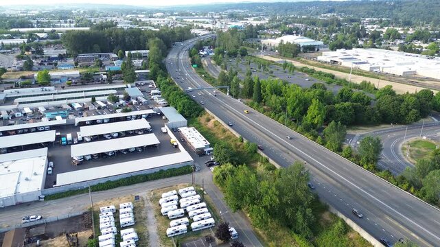 Storage facility grid state route 167 traverses warehouse zones defining Kent industrial heart. Parallel rows of vehicle shelters align against surrounding trees, showing structural order, WA
