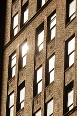 Sunshine reflecting on windows of apartment building © Pete Niesen Photo