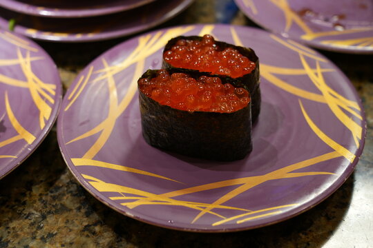 Fresh sushi on colorful plates in a Kaiten sushi restaurant in Japan