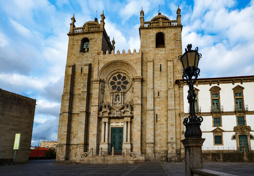 closeup of the front of the Catholic romanesque style cathedral's rose window and bell towers in Porto, Portugal, a UNESCO World Heritage Site
