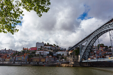 Obraz premium City buildings and D Luis Bridge over the Douro River along waterfront in Porto, Portugal