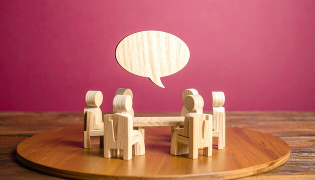 Wooden Peg Figures Gathered Around Round Table with Speech Bubble Communication Concept

