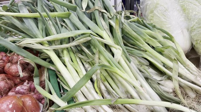A large bunch of fresh raw green leeks or scallions at traditional local market